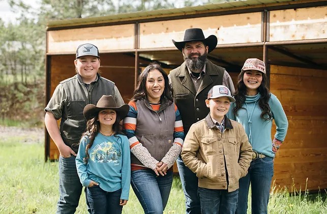 The Orcutt family standing in front of a 3-sided shelter